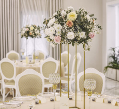 Elegancka dekoracja stołu weselnego z kwiatami na złotym stojaku – realizacja Firma Dekoracyjna Claudia w lokalu Na Wzgórzu w Grudnej Górnej