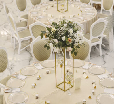 Elegancka dekoracja stołu weselnego z kwiatami na złotym stojaku – realizacja Firma Dekoracyjna Claudia w lokalu Na Wzgórzu w Grudnej Górnej