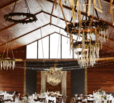 drewniane krzesła na wesele, dekoracja światełkami, ścianka boho drewniana i makrama