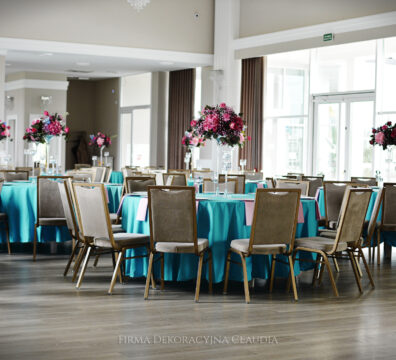 turkusowe obrusy i kwiaty na wysokim flakonie