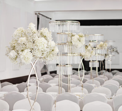 karuzele kryształowe na wesele, lustrzane blaty i świeczniki elipsa złote z eleganckimi bukietami z białych hortensji, róż i gibsówki