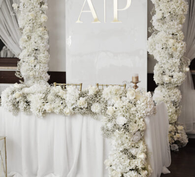 dekoracja ścianki państwa młodych z białych kwiatów glamour, białe panele i inicjały podświerlane