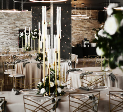 elegancka i romantyczna dekoracja weselna, świecznik ośmioramienny złoty, złote krzesła na wesele, obrusy w kolorze beżu, serwety szałwiowe