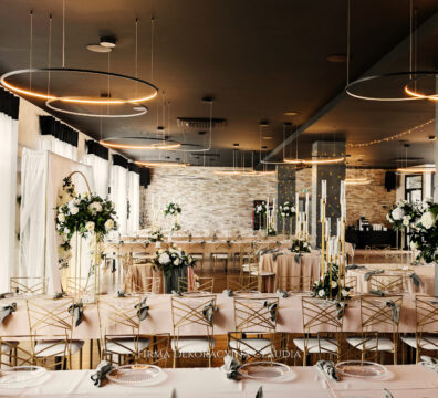 dekoracja weselna serwetami szałwiowymi, złota ścianka okrąg z ledonem, stojaki złote z bukietem, świeczniki ośmioramienne złote