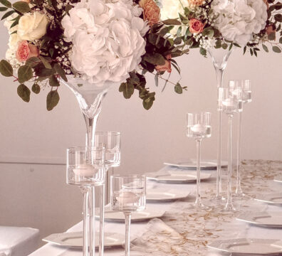 kwiaty na wysokim stojaku na wesele, dekoracja stolików na wesele, świece na wysokim szkle