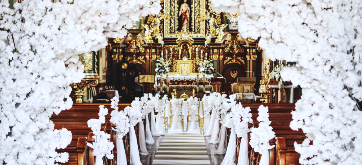 dekoracja kościoła bardzo elegancka, duży łuk z kwiatów wiśni, biały dywan, dekoracja ławek kwiatami wiśni, krzesła złote