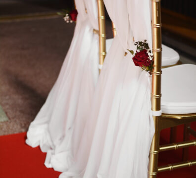 czerwony dywan do kościoła na ślub, złote krzesła z przeplecionym materiałem, czerwone róże do kościoła