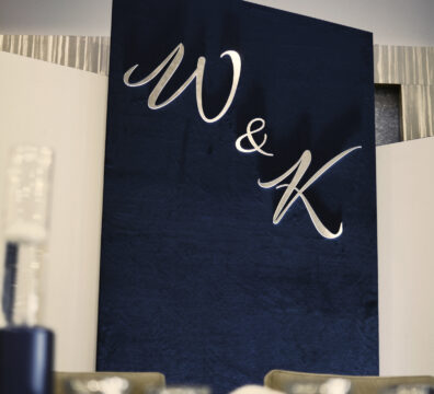 ścianka panelowa elegancka z granatowym welurem i srebrnymi podświetlonymi inicjałami