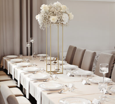 wysoki złoty stojak geometryczny z bukietem z białych kwiatów,