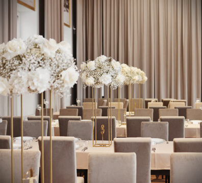 dekoracja stolików dla gości, beżowy obrys, złoty stojak kwietnik geometryczny z bukietami z białych kwiatów