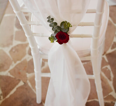 Bordowa dekoracja kościoła na ślub. Białe krzesła chiavari