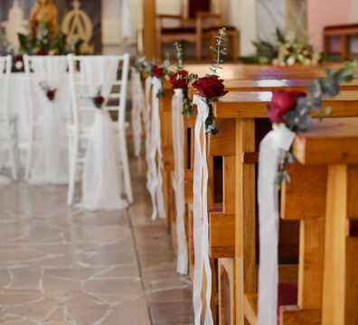 Bordowa dekoracja kościoła na ślub. Białe krzesła chiavari