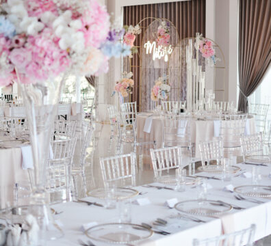 Pastelowe kolory, akrylowe krzesła na wesele, wysoki szklane flakony z bukietami, dekoracja stolików weselnych., podtalerze.