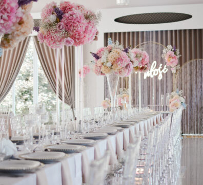 Pastelowe kolory, akrylowe krzesła na wesele, wysoki szklane flakony z bukietami, dekoracja stolików weselnych., podtalerze.