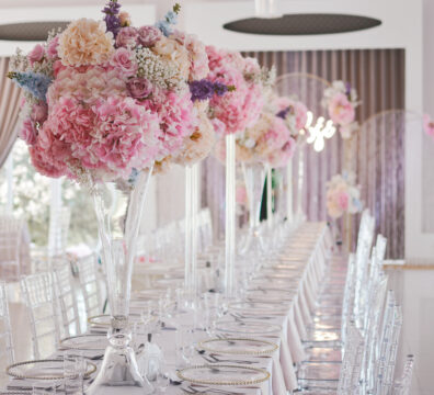 Wysokie flakony na stoliki na wesele, pastelowe kwiaty
